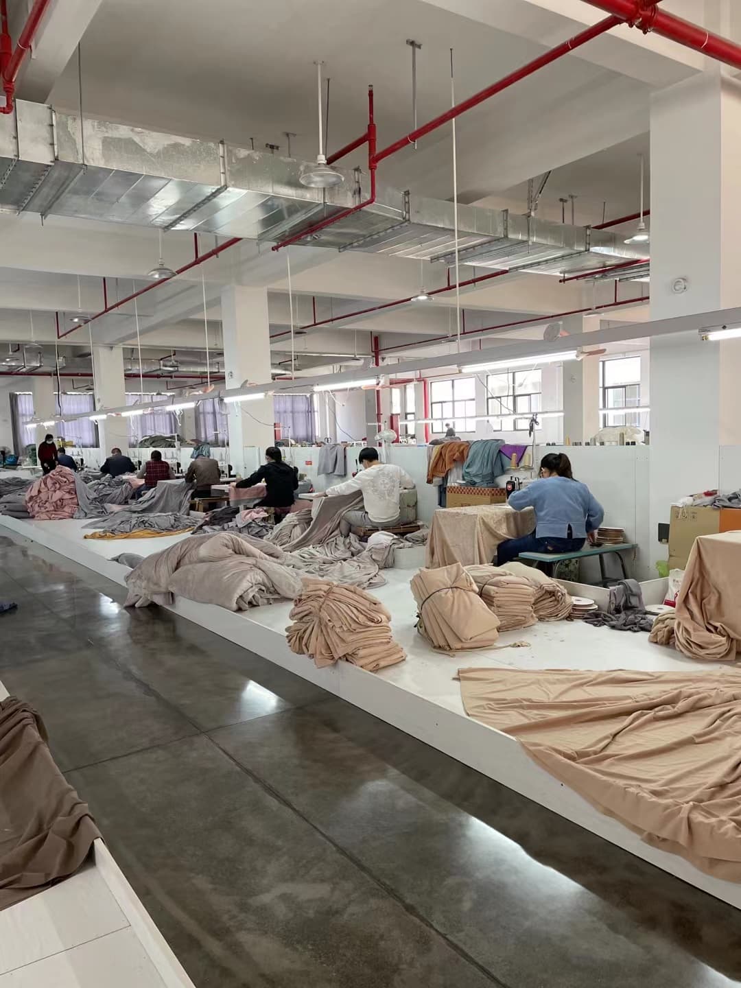 Garment factory floor with cutting tables and bundles of fabric mid-production